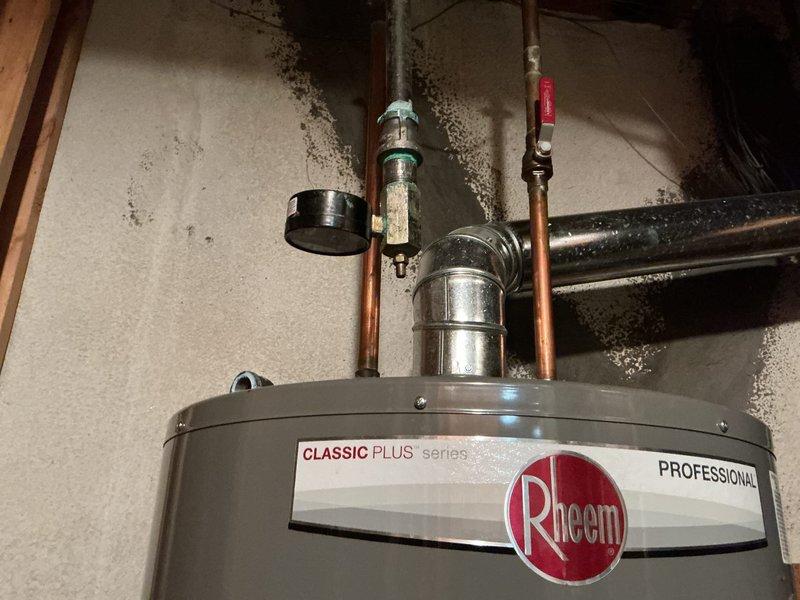 Conducted gas pressure test on Rheem Classic Plus Professional water heater with gas supply confirmed off by Consumers Energy (confirmation #89586-306-6689). Visual inspection of the unit revealed proper installation of copper pipes, metal fixtures, and ventilation components. Air test completed successfully with no leaks detected in the gas line system.