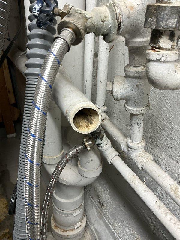 Repaired PVC pipe connection behind washing machine that had come loose and was leaking water. Inspected shower fixture and diagnosed water heater issue causing lack of hot water throughout the residence.