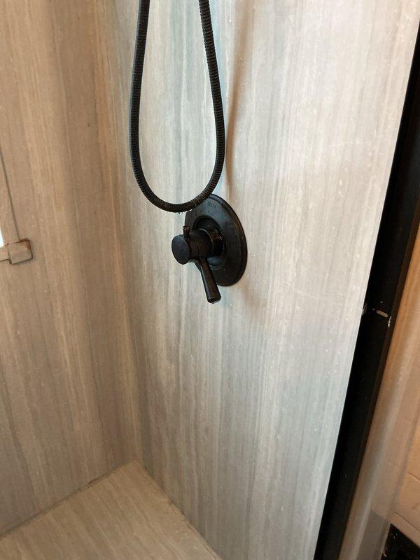 Repaired PVC pipe connection behind washing machine that had come loose and was leaking water. Inspected shower fixture and diagnosed water heater issue causing lack of hot water throughout the residence.