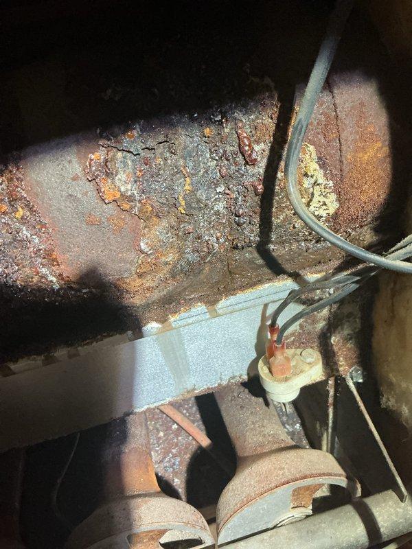 Diagnosed non-functional boiler that had previously experienced intermittent operation. Inspection revealed severe corrosion on critical piping components and damaged electrical connections, with significant rust accumulation on the pulley/belt assembly. Replaced deteriorated components, restored proper electrical connections, and successfully restored system operation.