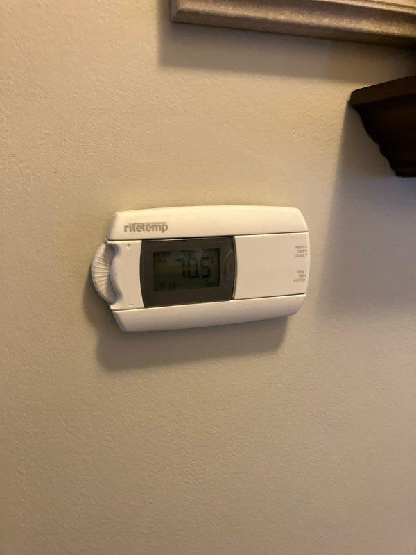 Conducted a comprehensive evaluation for full HVAC system replacement, including assessment of the existing outdoor unit showing significant weathering and oxidation on component enclosures. Inspected the current Ritetemp digital thermostat (displaying 70.5°F) and discussed potential rebate opportunities for the new system installation.
