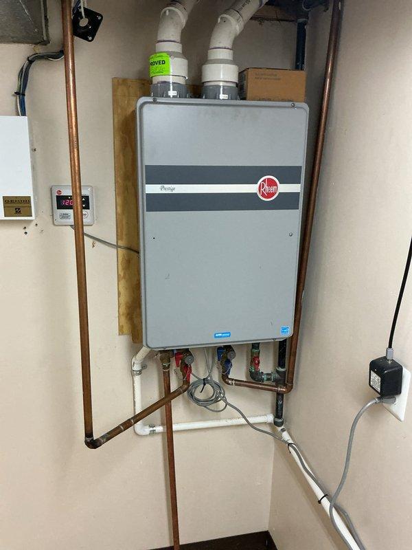 Performed comprehensive descaling maintenance on wall-mounted Rheem tankless water heater. Flushed system to remove mineral buildup, inspected all connections and verified proper venting through PVC pipes. Confirmed unit operating at 130° temperature setting with all valves functioning correctly.
