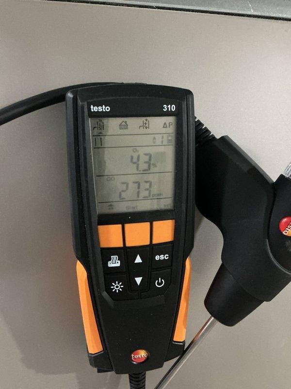 Performed combustion analysis on furnace using Testo 310, obtaining CO reading of 27.3 ppm and efficiency of 4.3%. Inspected gas valve connection, noting corrosion at pipe fitting, and verified proper gas supply through yellow valve to unit.