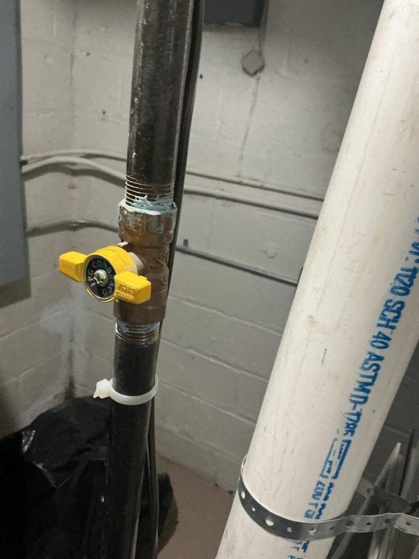 Performed combustion analysis on furnace using Testo 310, obtaining CO reading of 27.3 ppm and efficiency of 4.3%. Inspected gas valve connection, noting corrosion at pipe fitting, and verified proper gas supply through yellow valve to unit.