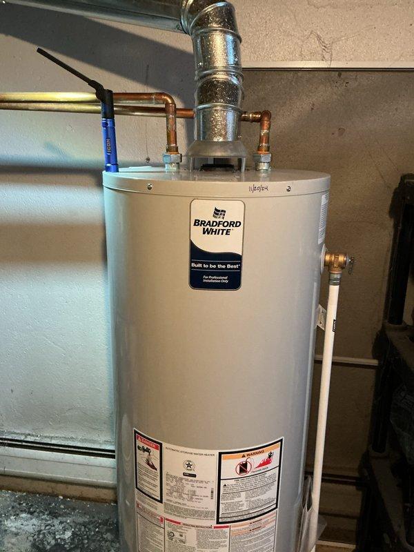 Performed comprehensive inspection of 16+ year old hot water boiler system located in basement. Examined copper supply lines, brass valves, and ventilation connections, finding all components in functional condition despite age-related discoloration. Inspected Bradford White water heater with attached copper piping and flue connections, confirming proper installation and operation with no visible leaks or damage present.