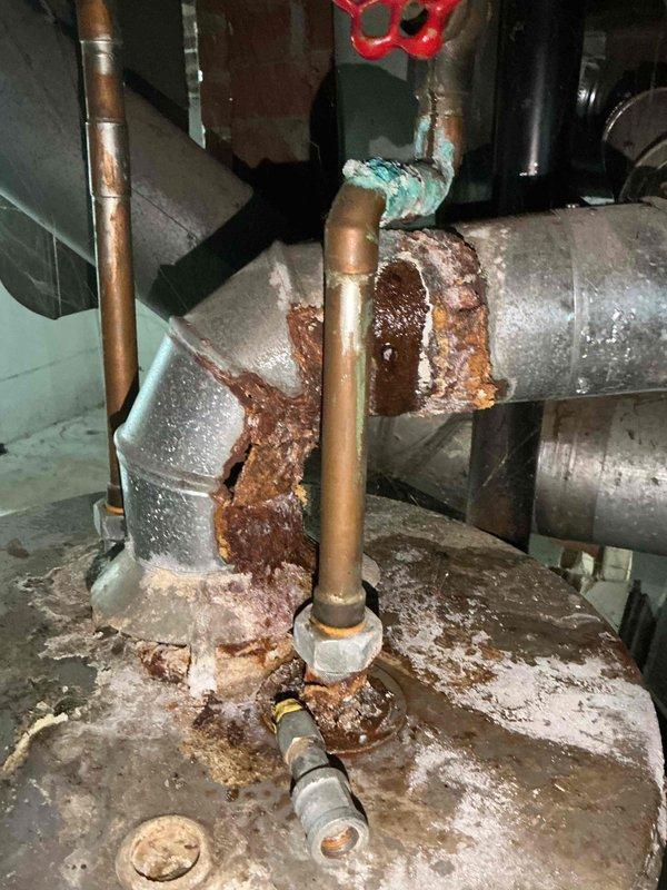 Performed routine tune-up on 20+ year old dual furnace system located in basement. Inspection revealed significant corrosion at plumbing pipe junctions with extensive rust buildup, particularly at metal/copper connection points. Internal examination of blower assembly and heat exchanger showed functional components, but recommended monitoring of corroded plumbing to prevent future failure.