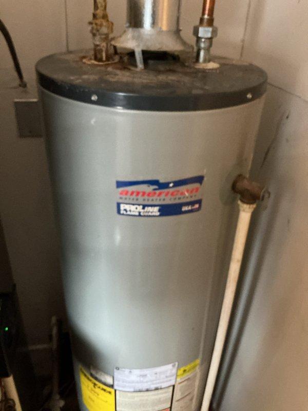Responded to service call for American ProLine tanked water heater with reported hot water outage and tank leakage. Inspected unit and identified corrosion at pipe connection point on top of heater, which was causing water leakage. Replaced damaged fittings, verified proper venting through galvanized exhaust pipe, and restored hot water functionality to residence.