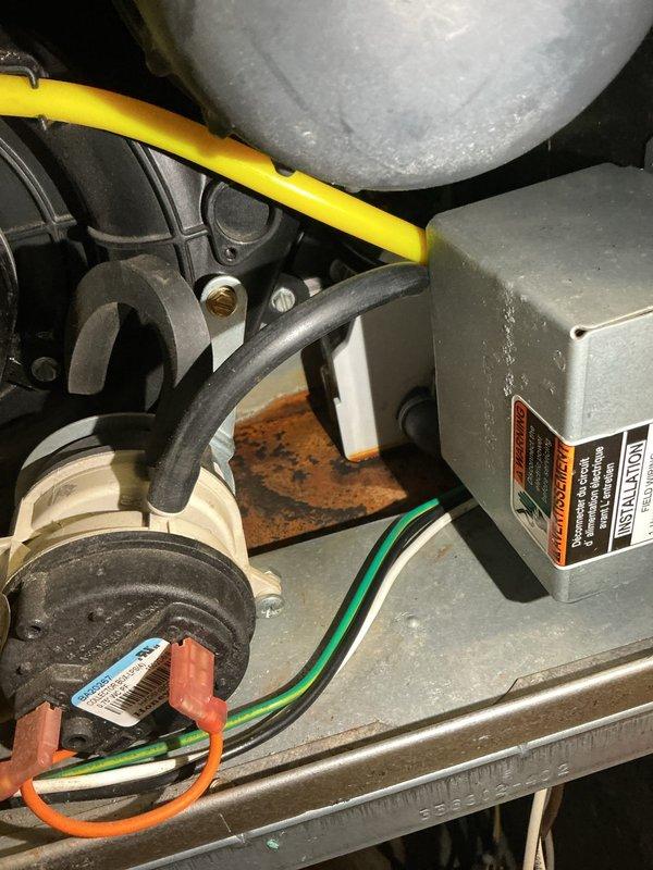 Responded to a service call for rusty water leaking from underneath an 11-year-old furnace in customer's basement. Determined the issue was related to the condensate trap, which had previously failed under warranty. Inspected internal components, documented corrosion, and replaced the defective condensate assembly to resolve the water leak while confirming proper system operation.