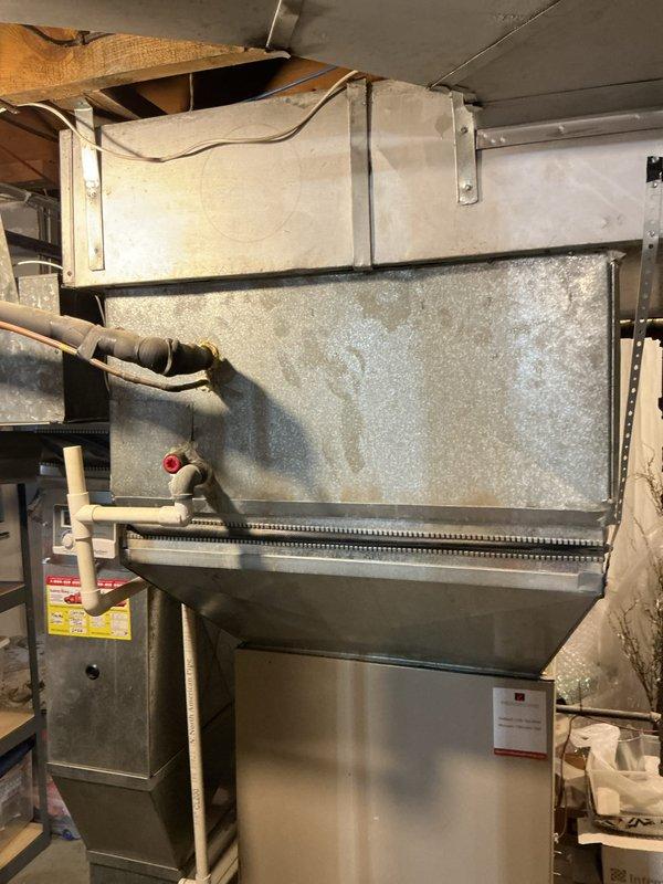 Performed inspection of 25-year-old HVAC system with faulty blower wheel causing noise issues. Identified damaged blower assembly in existing furnace unit located in basement utility area. Provided comprehensive replacement estimate for complete system due to equipment age and potential repair costs exceeding replacement value. Documented current installation configuration including existing ductwork connections and PVC venting system for proper sizing of replacement equipment.