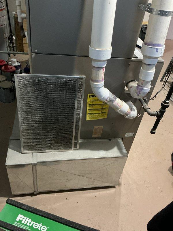 Conducted comprehensive inspection of 10+ year old furnace system located in basement. Documented existing installation including main unit with metallic cabinet, ventilation components, and PVC exhaust configuration. Prepared replacement quote for aging HVAC system with detailed specifications for upgraded equipment.