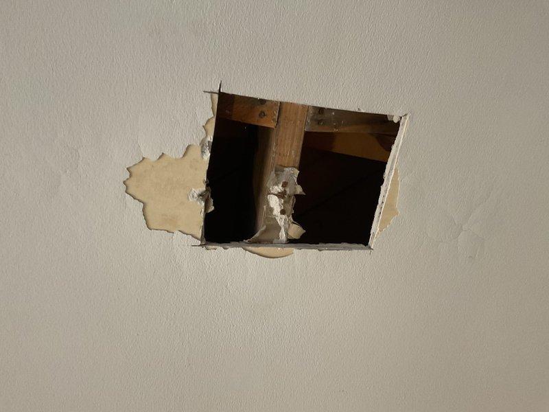 Performed follow-up inspection of previously identified ceiling water leak (Job #1230138). Cut access holes in drywall to investigate source of leak, revealing continued water damage that has spread since October assessment. Visual inspection confirmed ongoing moisture issues in the ceiling cavity. Documented current condition with photographs for comparison to previous assessment.