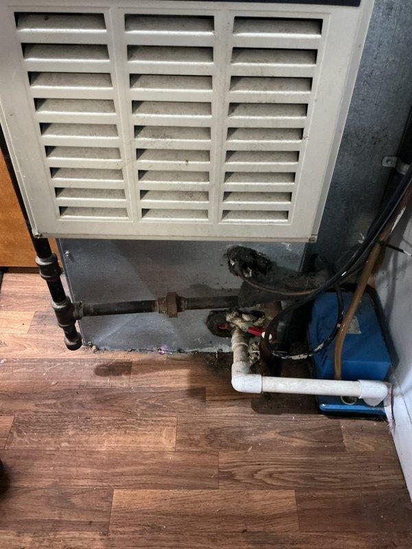 Performed diagnostic assessment on 10+ year old downflow furnace with cracked heat exchanger in mechanical room behind church. Inspection revealed non-functional secondary furnace failing to light or produce heat. Recommended full replacement as repair costs would be prohibitive given the extensive damage and age of the system.