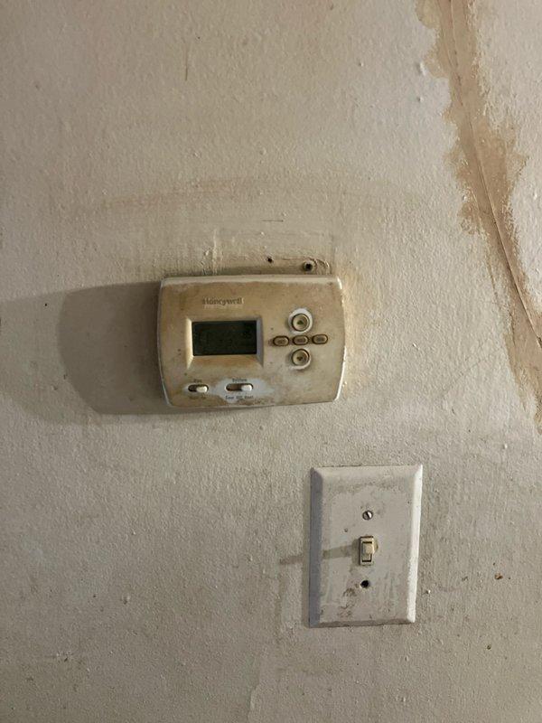 Performed diagnostic assessment on 2005 HVAC system in duplex basement (W unit) that was not producing heat. Found multiple issues including dirty flame sensor, inoperable toggle switch, and water-damaged control board. Temporarily restored operation by resetting system at breaker. Provided replacement options for this 18+ year old unit with documented water damage and control issues.