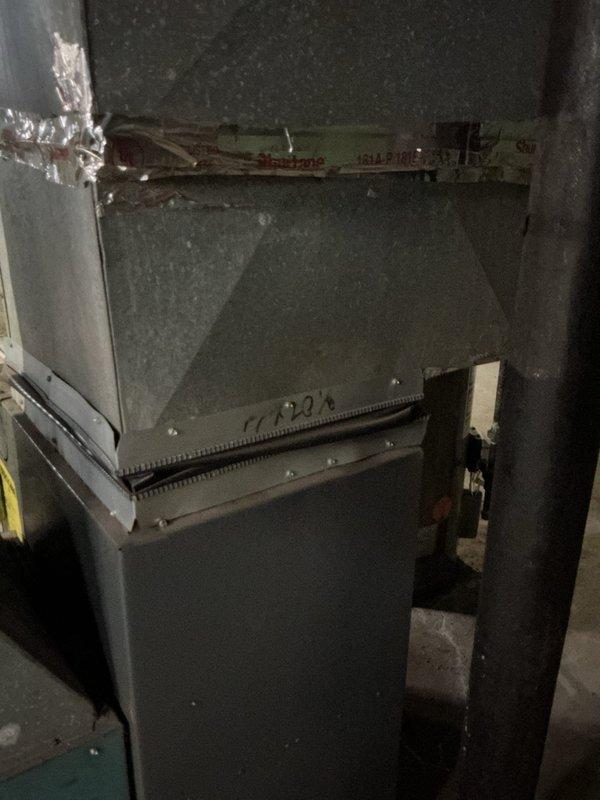 Responded to service call for 7-year-old furnace in basement that was cycling on and off intermittently. Diagnostic inspection revealed significant corrosion and deterioration on the heat exchanger cabinet, particularly around the blower assembly access panel. Observed damaged foil tape on ductwork connections and signs of extended wear on critical components. Recommended heat exchanger replacement to prevent complete system failure and restore proper operation.