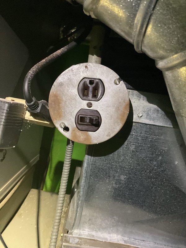 Responded to no-heat emergency where furnace failure caused connected pipes to burst, resulting in water damage throughout the basement of this 50+ year old two-story brick home. Inspected electrical connections and found weathered outlet plate with oxidation requiring replacement. Customer had already shut off water supply; recommended complete furnace replacement due to age (10+ years) and severity of damage to both the unit and surrounding plumbing infrastructure.