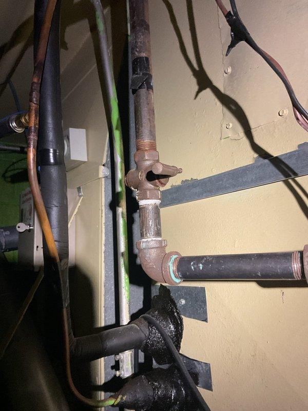 Responded to no-heat emergency where furnace failure caused connected pipes to burst, resulting in water damage throughout the basement of this 50+ year old two-story brick home. Inspected electrical connections and found weathered outlet plate with oxidation requiring replacement. Customer had already shut off water supply; recommended complete furnace replacement due to age (10+ years) and severity of damage to both the unit and surrounding plumbing infrastructure.