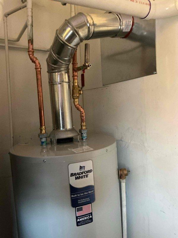 Successfully installed new Bradford White tanked water heater with proper connections to existing copper water lines. Installed drip pan with alarm as required by code, and completed all necessary venting with metallic vent piping. All connections were verified for proper function with no leaks observed.