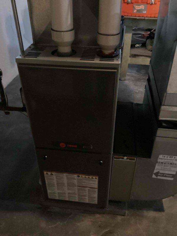 Inspected existing Rheem furnace system in basement location. Documented current installation including PVC exhaust venting, safety components, and adjacent air handler. Identified unit requiring replacement as indicated by service markings. Photos taken to document current setup and installation requirements for proper replacement specifications.