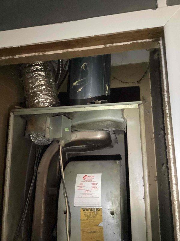 Performed diagnostic assessment on non-functioning 2006 furnace in mobile home kitchen closet installation. Identified flame rollout condition occurring when blower activates. Recommended complete replacement of 20-year-old system due to age and safety concerns, with optional AC replacement also discussed. Exterior inspection revealed existing outdoor condenser unit installed adjacent to home's exterior wall.