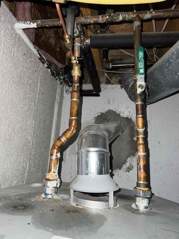 Returned under warranty to repair leak at hot water tank. Replaced severely corroded copper piping with two new 45-degree copper fittings. Observed significant mineral buildup and oxidation at connection points that had caused failure in the original installation.