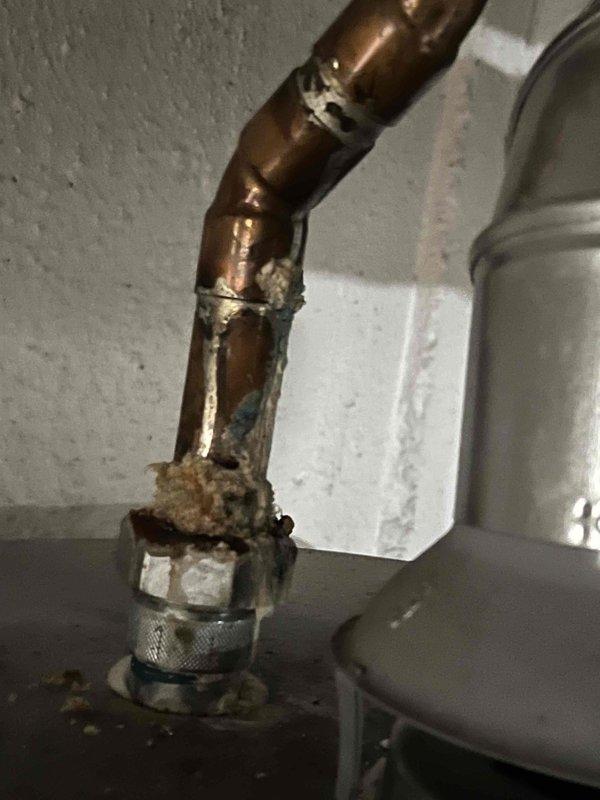 Returned under warranty to repair leak at hot water tank. Replaced severely corroded copper piping with two new 45-degree copper fittings. Observed significant mineral buildup and oxidation at connection points that had caused failure in the original installation.