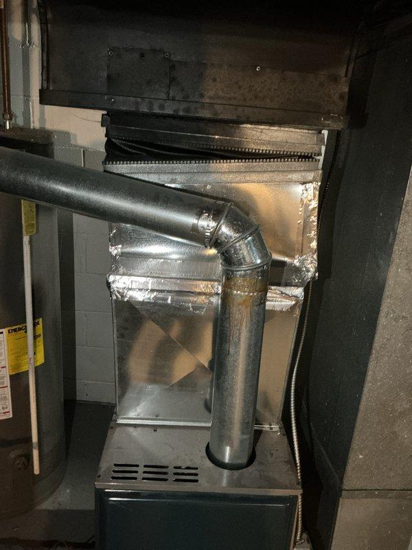 Completed full system estimate for existing HVAC installation, examining furnace with connected metallic ductwork, visible seams, and metal tape/sealant work. Inspection included evaluation of water heater with associated copper piping and control components, documenting current system condition through comprehensive photography for quote preparation.