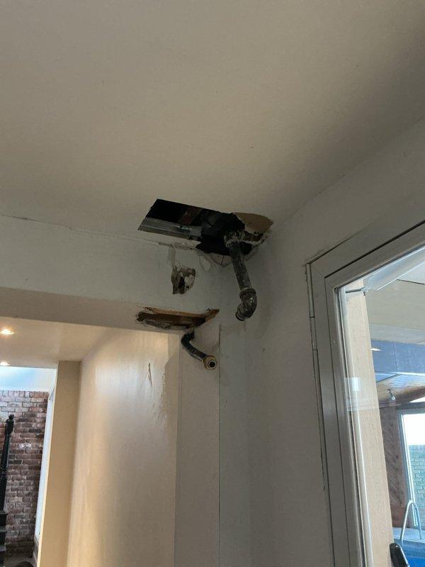 Responded to a service call regarding a water leak. Upon inspection, found ceiling damage with exposed ductwork and piping visible through an opening in the drywall. Determined the source to be a disconnected pipe near the furnace/boiler system in the utility room, which was not directly attached to the HVAC equipment. Advised customer that plumbing repairs would be necessary to resolve the issue completely.