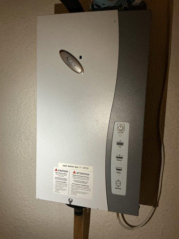Responded to service call for Aprilaire humidifier showing red service light. Inspected system and replaced steam canister and electrodes to restore proper operation. Verified Atmor tankless water heater (installed 11-2019) was functioning correctly and confirmed humidity control panel now displays appropriate readings.