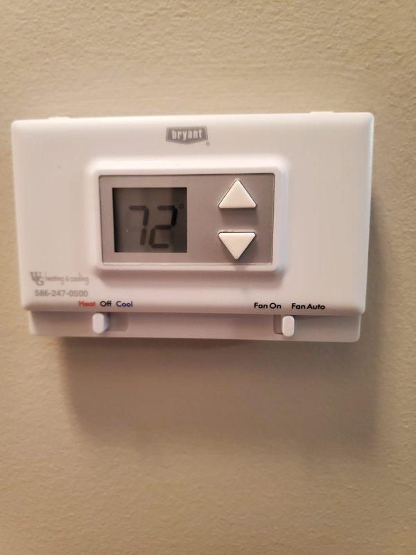Responded to service call for furnace not holding temperature despite recent thermostat battery replacement. Inspected Bryant thermostat and verified proper operation with display showing correct temperature (72°F). Examined basement utility area including drainage system and associated mechanical components; found system functioning normally with no issues requiring repair.