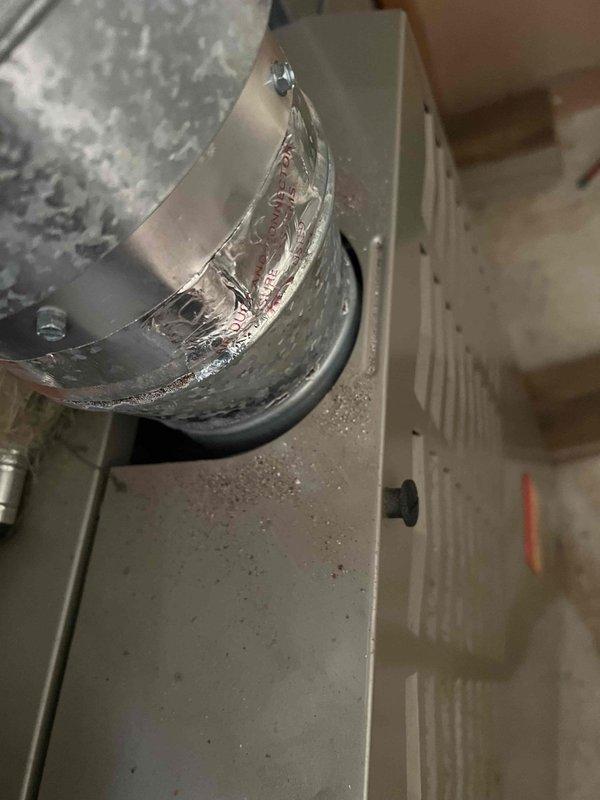 Responded to no-heat call for 10+ year old furnace with operational blower but non-functioning burner. Inspection revealed severe water damage and mold growth on nearby wall, along with condensation at the duct connection point. Determined moisture intrusion was causing system failure and recommended immediate remediation of water damage and evaluation of potential furnace replacement due to age and condition.