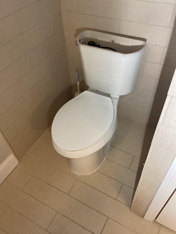 Completed installation of a new faucet in customer's bathroom, requiring removal of the existing fixture and proper connection to the under-sink plumbing system. Successfully installed and secured the dark basin/sink to the wooden counter using appropriate mounting hardware, and connected the white PVC drain assembly with P-trap configuration. All connections were tested for leaks and proper drainage.