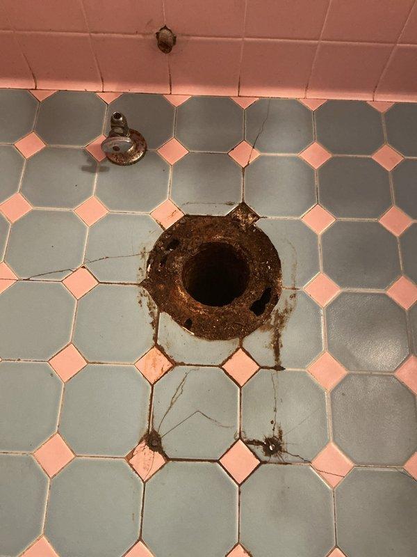 Completed installation of a comfort height elongated toilet, replacing the previous fixture which had caused significant water damage and rust to the vintage octagonal tile flooring. Installed new toilet flange to address severe corrosion issues at the waste pipe connection, ensuring proper seal and preventing future leakage.