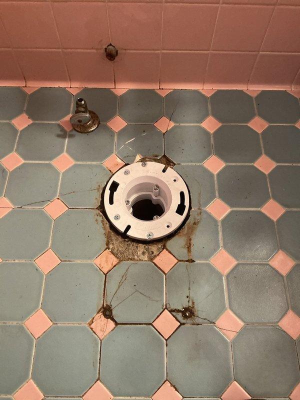 Completed installation of a comfort height elongated toilet, replacing the previous fixture which had caused significant water damage and rust to the vintage octagonal tile flooring. Installed new toilet flange to address severe corrosion issues at the waste pipe connection, ensuring proper seal and preventing future leakage.
