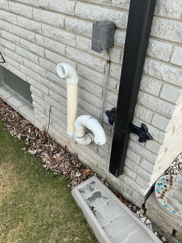 Performed diagnostic evaluation on 10-year-old furnace system located in basement due to complaint of blowing cold air. Inspection revealed failed secondary heat exchanger. Provided comprehensive replacement estimate for new furnace system, documenting existing installation configuration and exterior venting/drainage components for proper system matching.