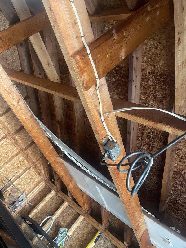 Conducted assessment of outdoor flood lights and evaluated requirements for doorbell electrical connection and exterior outlet installation. Inspected junction box in unfinished space, noting existing wiring configuration and structural mounting. Documented electrical pathways and connection points to determine optimal routing for new exterior applications.