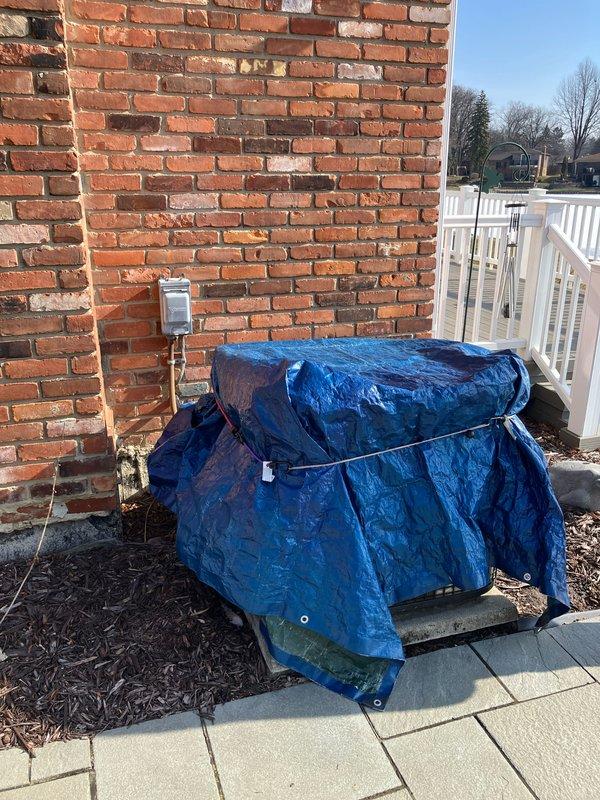 Conducted assessment of non-functioning 10+ year old AC unit and possible furnace replacement in basement location. Inspection revealed outdoor unit (currently covered with protective tarp) showing significant age deterioration and connected to natural gas supply. Recommended complete system replacement to restore cooling functionality and improve energy efficiency.