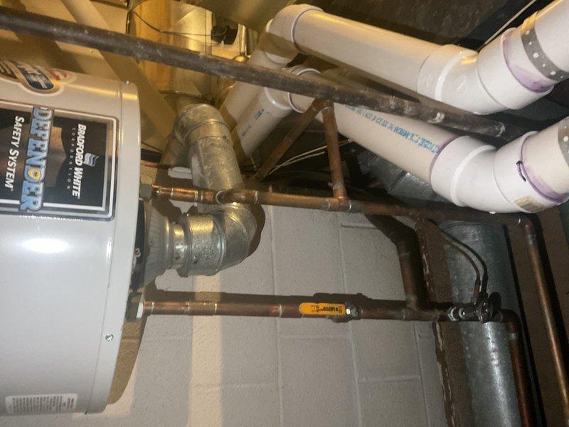 Performed diagnostic service on 8-year-old tanked water heater exhibiting intermittent hot water supply issues. Inspected the "Defender System" and associated copper/PVC piping configuration. Identified and addressed mineral buildup in the heat exchanger affecting temperature consistency, restoring proper hot water functionality.