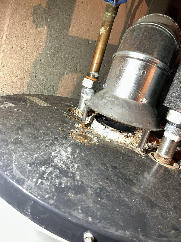 Performed comprehensive tune-up on 16-year-old HVAC system located in basement. Inspection revealed a heavily soiled air filter requiring replacement and significant corrosion/mineral buildup at the hot water tank connection point with evidence of possible leakage. System assessment included thorough examination of humidifier, thermostat, and hot water tank as specified.