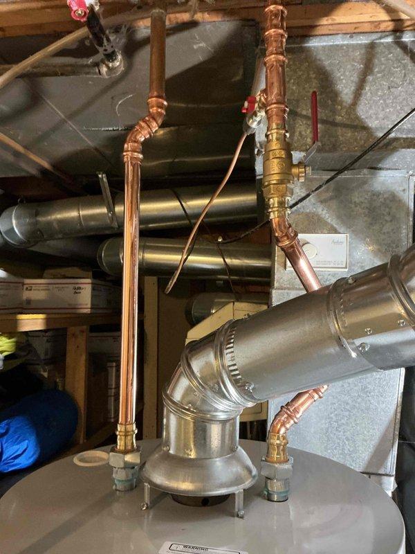 Successfully completed installation of gas hot water heater with proper venting in utility area. Work included connecting copper supply lines with brass valves and fittings, installing galvanized steel ventilation ducts, and ensuring all connections were secure and functional. Final inspection confirmed proper operation of the unit with no leaks.