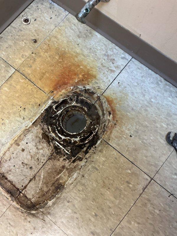 Responded to service call for toilet drainage issue. Used snake to clear severe blockage in floor drain that had caused significant water damage, rust staining, and deterioration of surrounding flooring. Successfully restored proper drainage function and documented condition with photos for customer records; invoice sent via email as requested.