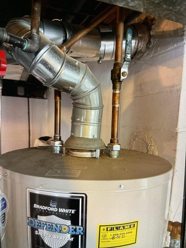 Performed Gold Furnace Inspection on a 1-year-old forced air system located in the basement. Inspected Bradford White "Defender" water heater system, confirming proper ventilation through galvanized metal ducting and verifying all plumbing connections were secure. Used hex key tool for minor adjustments during the inspection process.