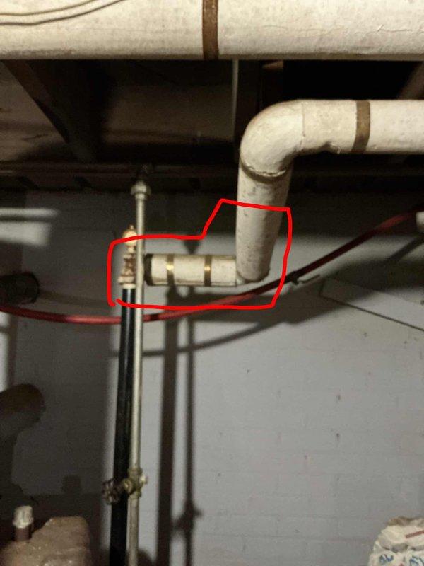 Conducted a comprehensive boiler estimate in residential utility room, documenting an American brand water heater system with associated plumbing components. Inspection revealed an older furnace/boiler unit with connecting copper pipes, valves and fittings, with particular attention paid to a valve connection on PVC piping that was highlighted for potential service.