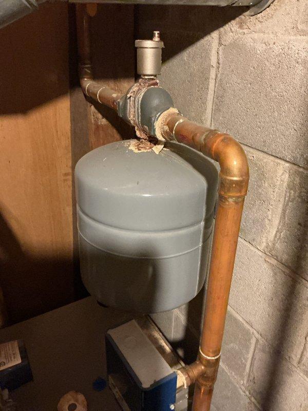 Performed Gold Boiler Inspection and identified significant corrosion at pipe connections with visible water leakage from the unit. Documented extensive deterioration at joint areas with rust and mineral deposits, particularly around the expansion tank connection to copper piping. Photos were taken to document the condition for further assessment of repair needs.