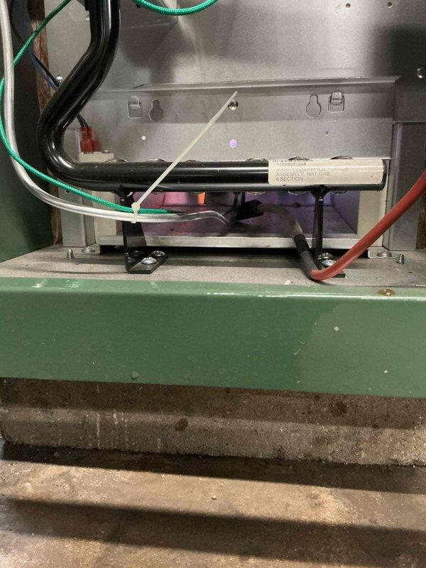 Responded to callback for recently installed boiler system exhibiting a minor water leak. Inspected the installation, focusing on the valve assembly and copper pipe connections where moisture was evident. Tightened brass water valve fittings with blue gaskets to resolve the leak issue.