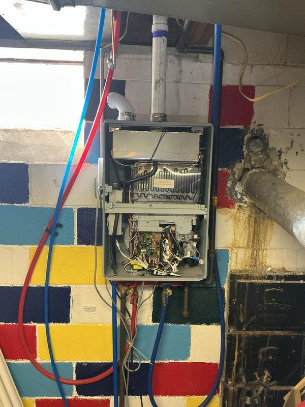 Diagnosed and serviced tankless water heater displaying error code 12. Inspected internal components including circuit board, wiring, and heat exchanger. Identified potential issues with water supply lines and examined nearby plumbing infrastructure, noting interaction between newer copper pipes with brass fittings and older galvanized metal pipes in the system.