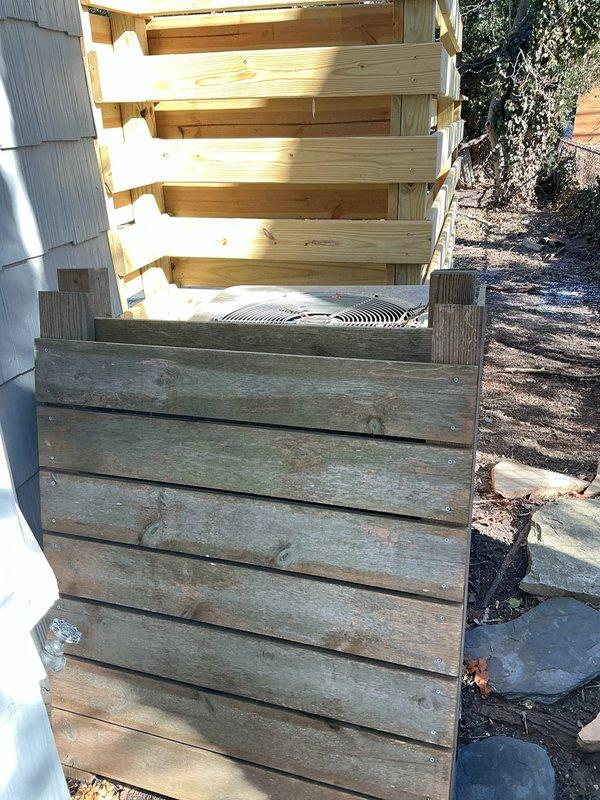 Performed inspection of residential property to generate replacement estimate for 50+ year old HVAC system. Observed outdated furnace and AC unit located in basement, with exterior condenser showing significant deterioration including cracked concrete top and weathered components. Documented existing wooden enclosure surrounding outdoor unit which will need modification during replacement to accommodate modern equipment specifications.