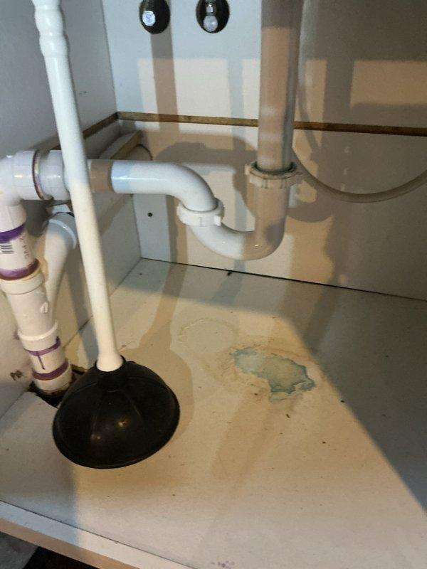 Repaired water leaks in laundry room and bathroom sinks by replacing damaged PVC drain pipes and connectors showing visible water damage. Addressed water heater backdrafting issue in 50-gallon unit by inspecting and resealing improper wall penetrations where galvanized pipes enter, which were contributing to the backdraft condition.