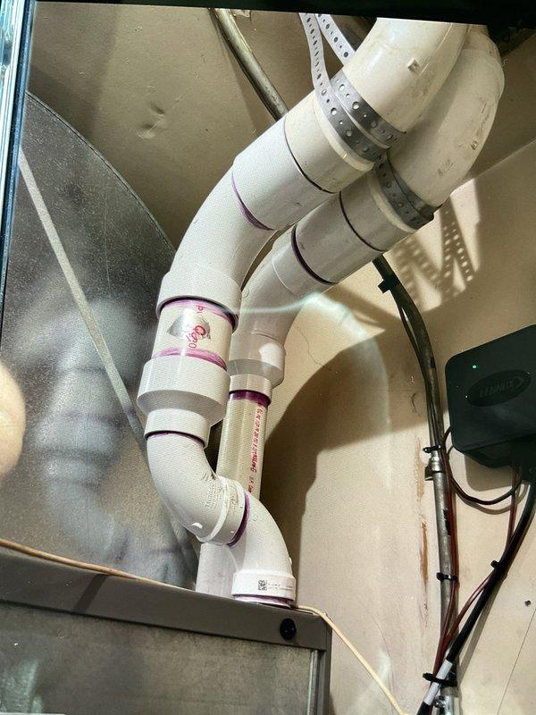 Resolved issue with improperly installed exhaust pipe that was discharging into attic and causing water damage to rafters. Rerouted and properly installed PVC exhaust pipe with appropriate elbow joints and secured with metal strapping. Verified fresh air intake was correctly positioned outside the building as required by manufacturer specifications.