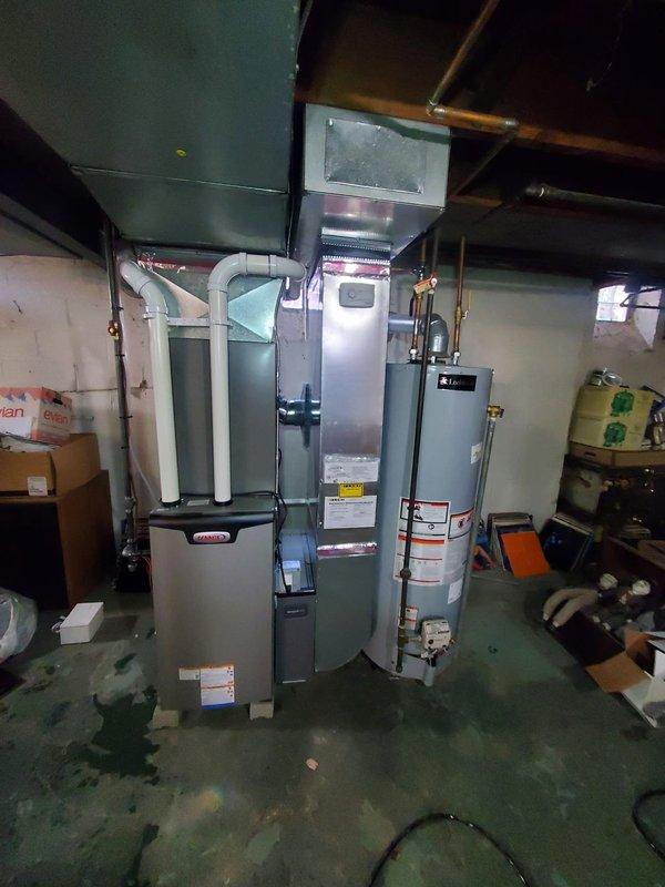 Responded to service call for water leak from a one-year-old furnace located in basement. Upon inspection, identified and repaired leaking water line while documenting pre-existing moisture stains on concrete floor. System remained operational throughout service with no interruption to heating function.