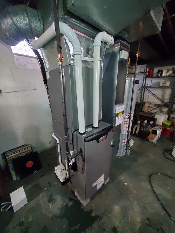 Responded to service call for water leak from a one-year-old furnace located in basement. Upon inspection, identified and repaired leaking water line while documenting pre-existing moisture stains on concrete floor. System remained operational throughout service with no interruption to heating function.